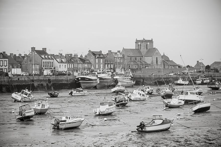 Fischerboote liegen im Hafen von Barfleur bei Ebbe auf Grund