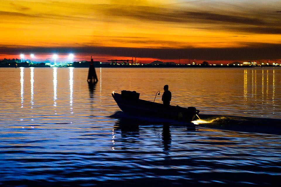 kleines Fischerboot in der Lagune von Venedig im goldgelben Sonnenuntergang